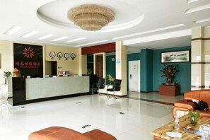 A hotel reception area with a reception desk, seating, and a chandelier. - Ningbo Sunshine Yiran Hotel (Ningbo)