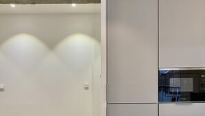 A modern kitchen with a built-in microwave and a refrigerator.