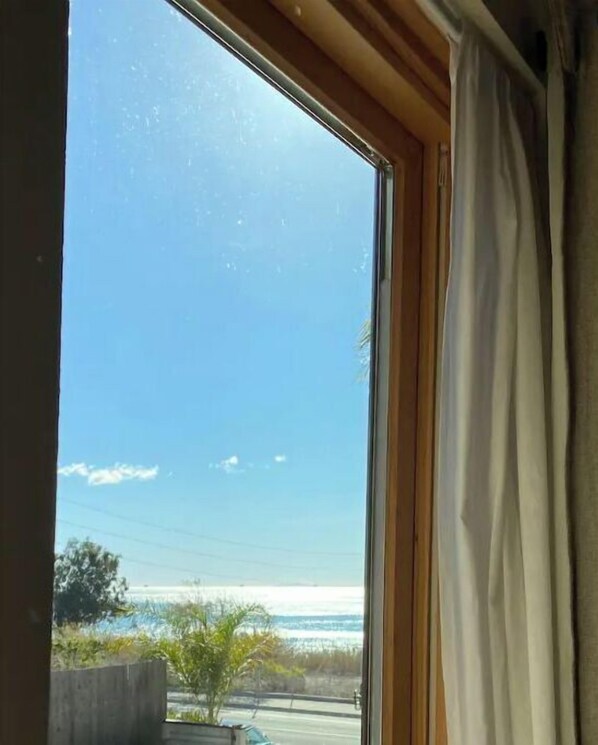 Enjoy the ocean view from this room's window, which offers a glimpse of the distant sea.
