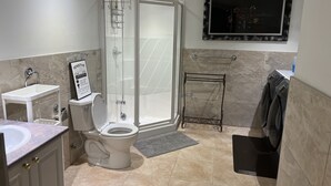 Un baño moderno con inodoro, lavamanos, ducha y toallero.
