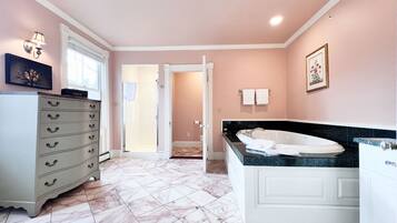 A bathroom with a marble floor, a bathtub, a vanity, and a tissue box on a cabinet.
