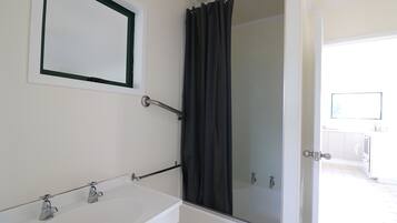 Une salle de bain équipée d’une baignoire, d’un espace douche et de toilettes.