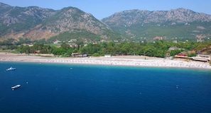 A coastal area with a beach, boats, and mountains in the background. - Luxury Villa with Pool Near the Beach in Kalkan, Antalya- Sleeps up to 15 Guests (Antalya)
