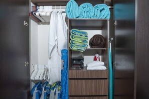 A wardrobe with multiple shelves, some with folded clothes and others with neatly stacked towels.
