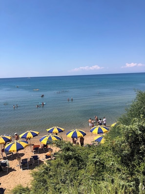 Relax on the beach with shaded seating areas and calm waters.