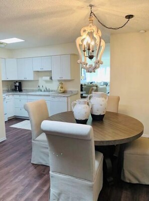 Modern kitchen with a central island, chandelier, and round dining table.