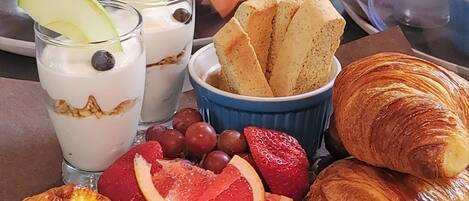 Un bufé de desayuno con diversos pasteles, frutas y bebidas.