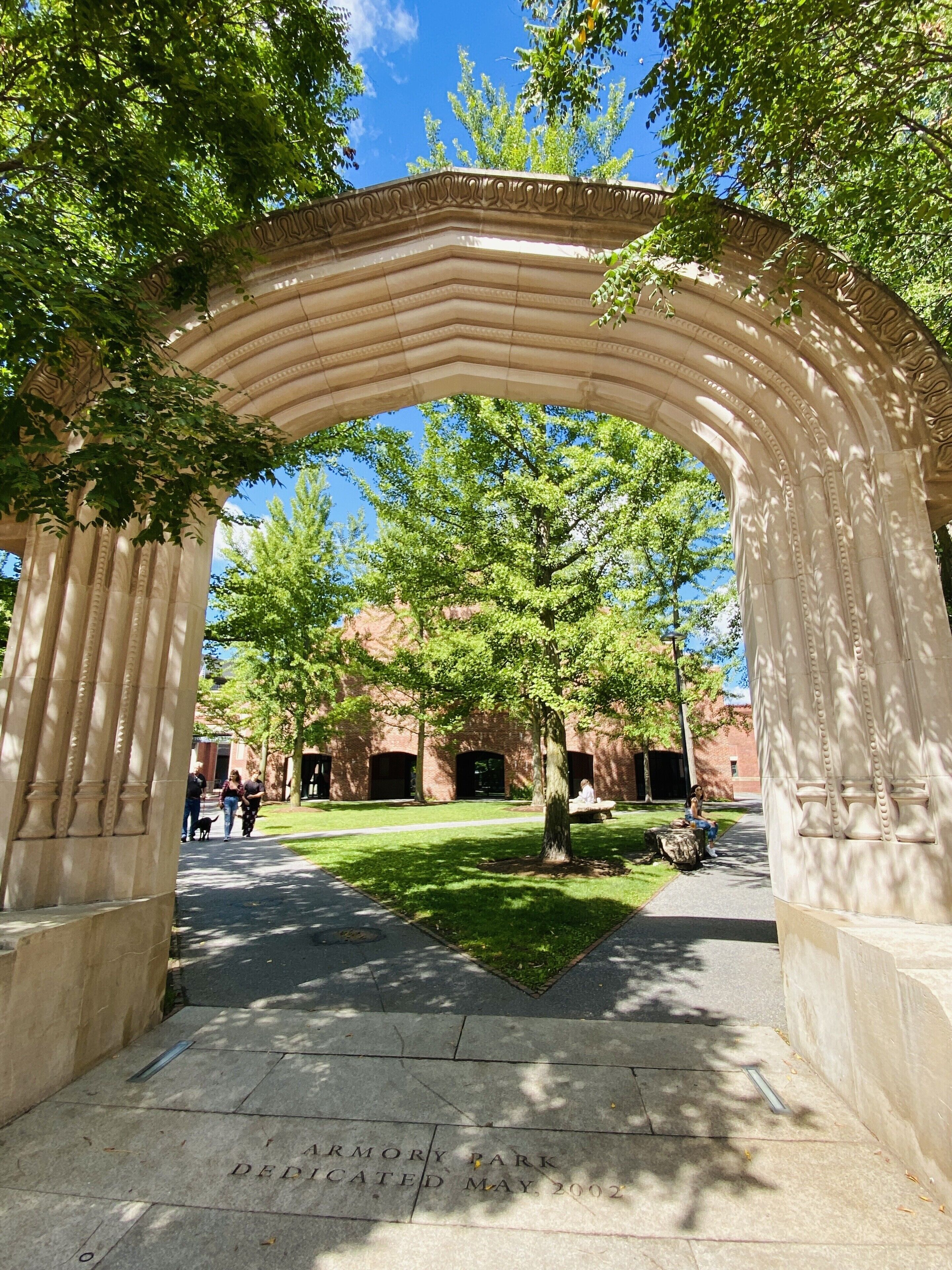 Una struttura in pietra ad arco con una targa che recita: “ARMORY PARK DEDICATO A MAGGIO, 2002”.