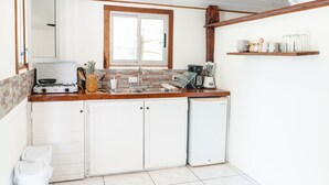Uma cozinha compacta com fogão a gás, liquidificador e cafeteira.