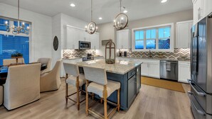 A modern kitchen with a central island, white cabinetry, stainless steel appliances, and pendant lighting. - Reel Oasis, family-friendly, pet friendly, pool, boat slip, golf and on lake LBJ (Kingsland)