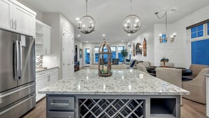 A modern kitchen with a large island, stainless steel appliances, and pendant lighting. - Reel Oasis, family-friendly, pet friendly, pool, boat slip, golf and on lake LBJ (Kingsland)