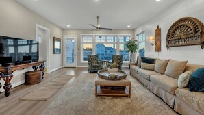 A spacious living room with a large TV, comfortable seating, and a view of the outside. - Reel Oasis, family-friendly, pet friendly, pool, boat slip, golf and on lake LBJ (Kingsland)