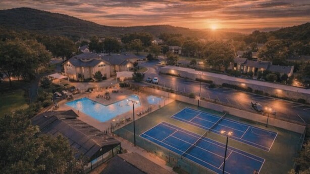 Zona residencial amb piscina, pistes de tennis i cases.