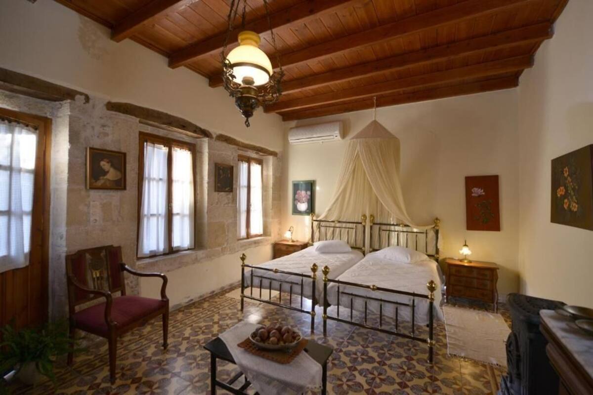 Une chambre à coucher avec un lit, une chaise, une table de chevet et une lampe.