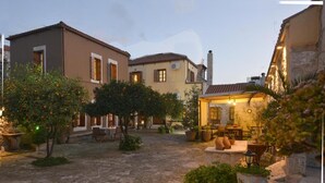A courtyard with stone flooring, potted plants, and outdoor seating. - Troullos Traditional Houses (Archanes-Asterousia)
