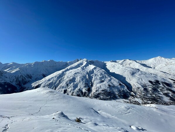 A snow-covered mountain landscape with clear skies.