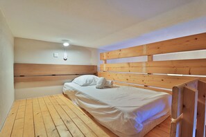 Une chambre à coucher avec une tête de lit en bois, un lit simple et une table de chevet.