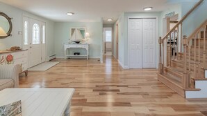 Um quarto amplo com piso de madeira, uma escrivaninha, uma cadeira e uma escada.