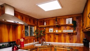 A rustic kitchen with wooden walls, a white stove, and a wooden countertop. - The Building on The River R&R  (Riggins)