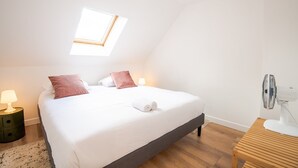 A bedroom with a bed, two bedside lamps, a ceiling fan, and a small table. - Le Quai des Marais - Coeur d'Amboise (Amboise)