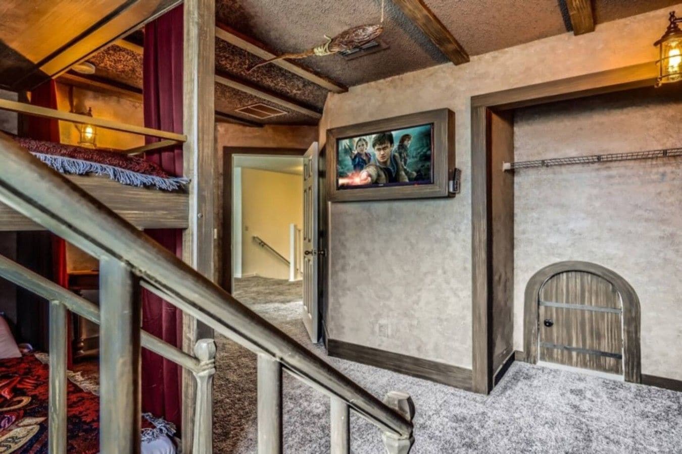 A staircase with a wooden handrail leading to a room with a framed picture on the wall.