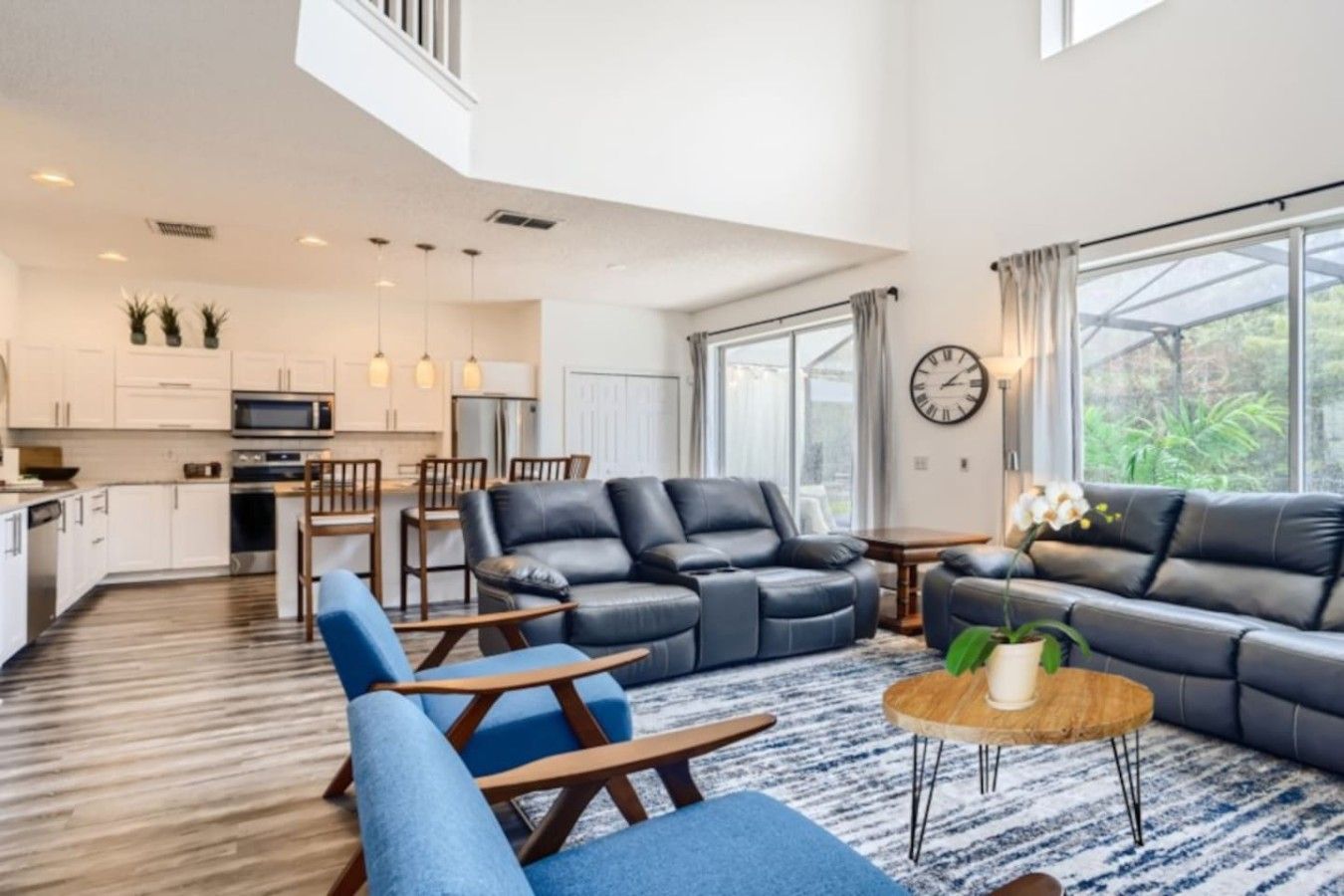 A modern living room with a sectional sofa, a coffee table, and a dining area with chairs.