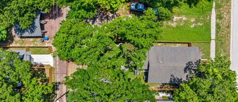 An aerial view of a residential area with houses, trees, and a clear sky.