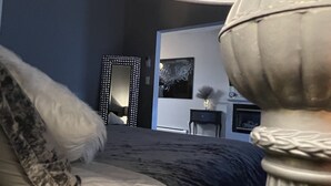 A bedroom with a bed, a mirror, and a dresser. - Modern condo with jacuzzi in the heart of downtown. (Wabasha)