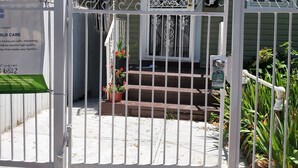 A gated entrance to a house with a mailbox, a number sign, and a small porch with steps. - Cosy Studio in a Private home with private entrance and door (Bronx)