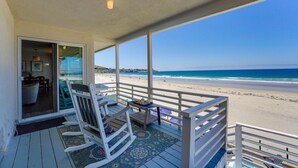 A covered deck with a view of the beach, a rocking chair, and a small table. - Blue Sea Villa, Centered in La Jolla Shores! (San Diego)