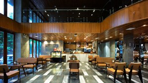 A modern cafe with a central counter, seating area, and large windows. - LIVIE DANANG ANTHUONG (Da Nang)