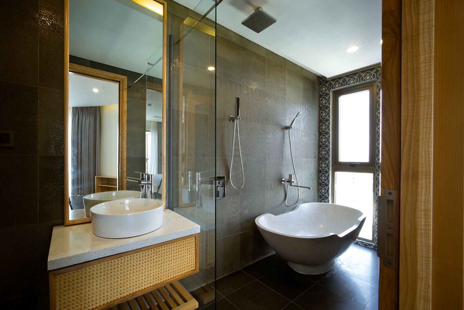 A modern bathroom with a glass-enclosed shower, a freestanding bathtub, and a round sink.