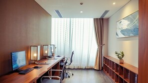 A modern office with a long desk, multiple monitors, and a large window with curtains. - Mikazuki Villas - The Ryokan (Da Nang)
