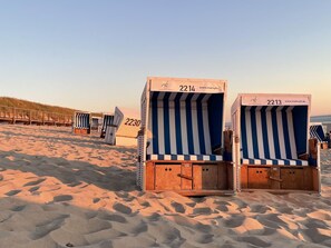 Beach huts numbered 2214 and 2213 with a sandy beach and dunes in the background. - Ocean View II - Modern apartment with ocean view, west-facing balcony, Wi-Fi. Pets allowed. (Sylt)