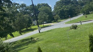 Une rue résidentielle bordée d ’une pelouse verdoyante, d’arbres et d’un panneau de signalisation indiquant un arrêt obligatoire.