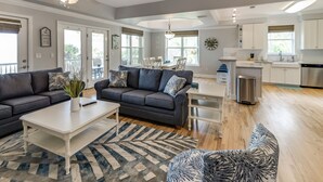 Un salon moderne avec un canapé gris, une table basse blanche et un tapis à motifs.