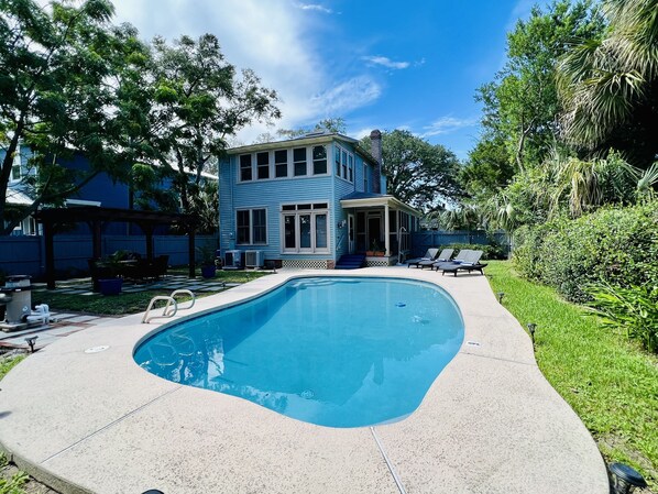Une piscine avec une maison en arrière-plan.