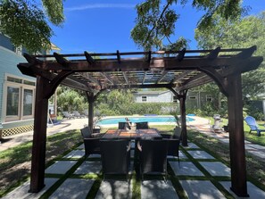 A covered patio area with a pool, outdoor furniture, and a pergola structure. - NEW Historic Vacation Home St. Augustine with Pool ! (St. Augustine)