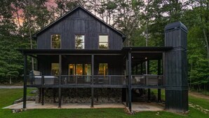 A two-story wooden house with a balcony, stone foundation, and a chimney. - FightingTown Escape | Blue Ridge, GA (McCaysville)