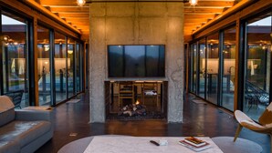 A modern living room with a large TV, a fireplace, and a comfortable seating area. - Hudson Ridge / Hot Tub, Fire Pit & Fireplace (Hudson)