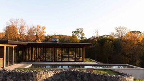 A modern house with a glass facade, a swimming pool, and a stone retaining wall. - Hudson Ridge / Hot Tub, Fire Pit & Fireplace (Hudson)