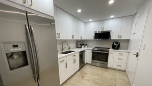 Een moderne keuken met witte kasten, roestvrijstalen apparatuur en een ingebouwd waterdispenser.