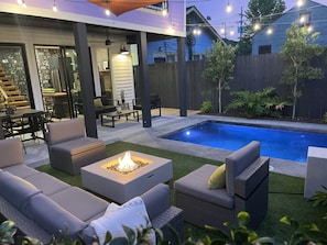 An outdoor patio area with a pool, seating, and a fire pit. - Hidden Oasis With Private Pool - Near FQ (New Orleans)