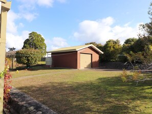 Situated in a serene grassy area, this single-story building features a large garage door and a small attached structure.