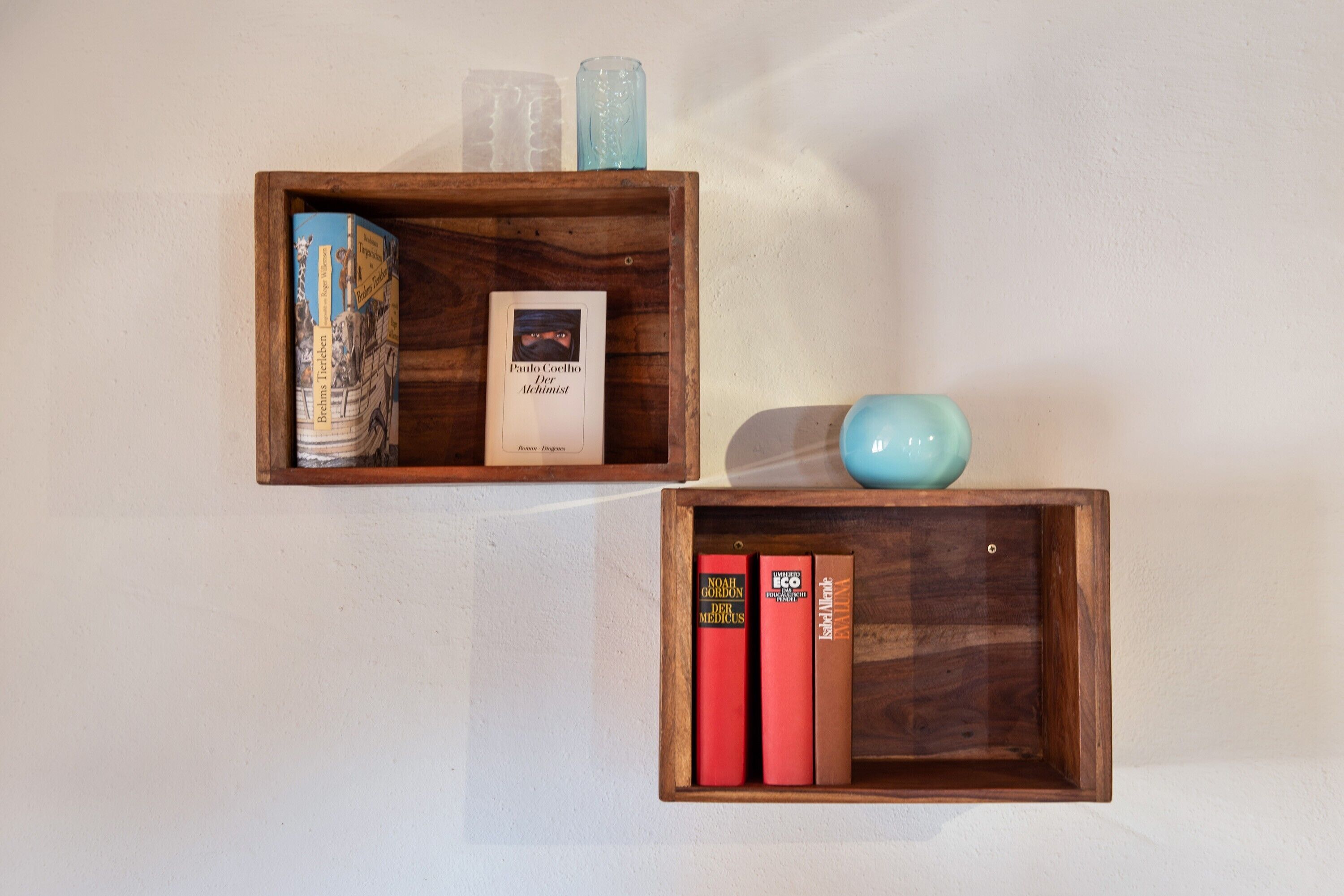 Dues prestatgeries de fusta amb llibres i objectes decoratius.