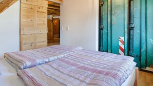 Une chambre à coucher avec un lit, une armoire en bois et une porte verte.
