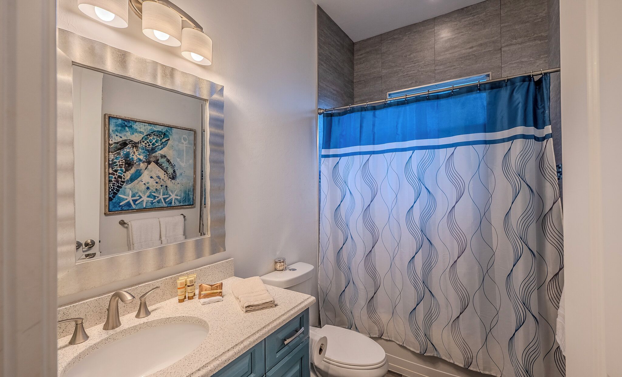 A bathroom with a sink, mirror, and toilet.