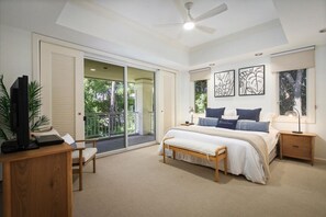 Relax in this serene bedroom with a large bed, desk, and chair, and enjoy the view from the balcony.
