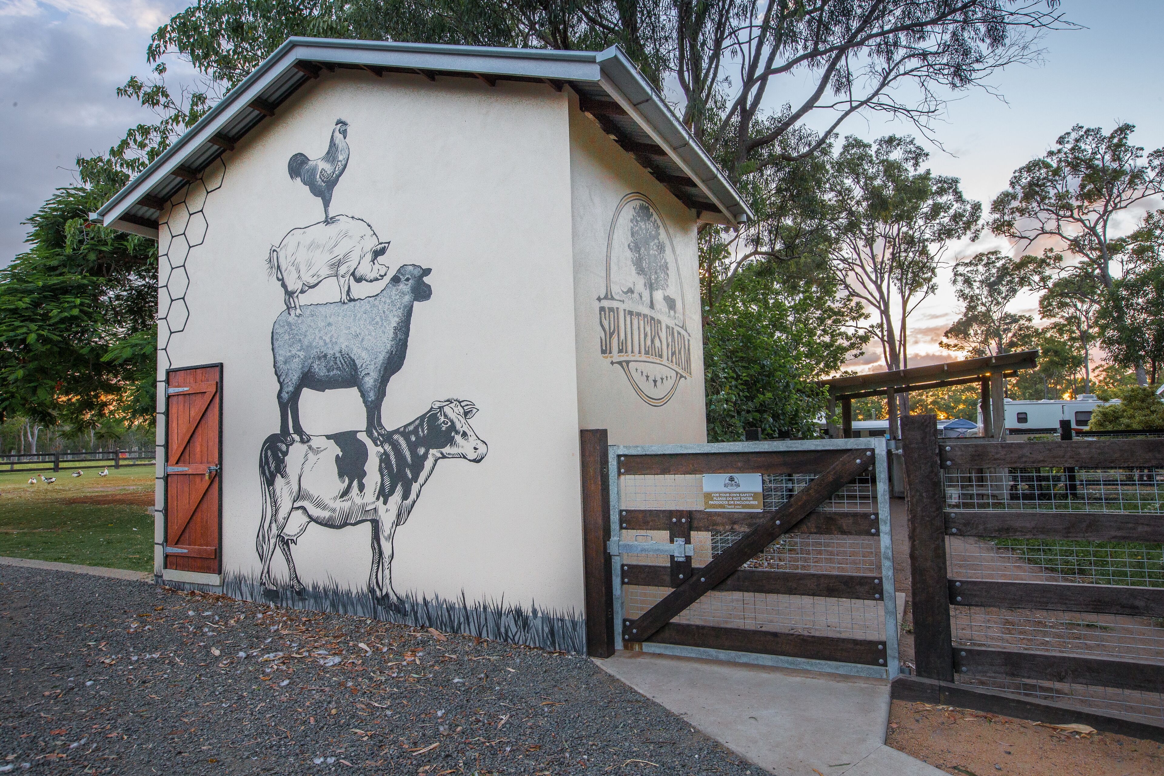 A building with a mural of a rooster and a cow, labeled "Splutters Farm."