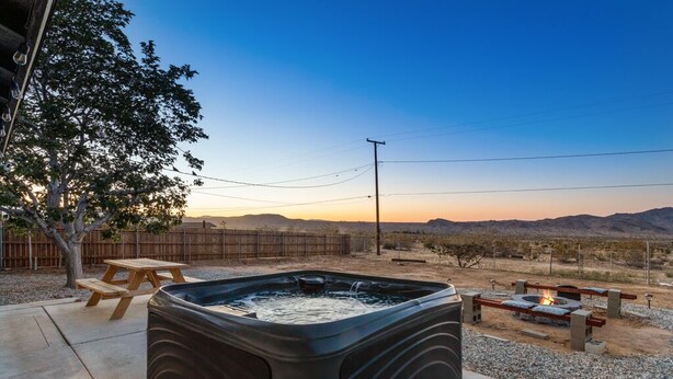 A hot tub in a backyard with a wooden table and a fire pit. - New 20% discount - Backyard PARADISE - JT Escape w/ Hot Tub (Joshua Tree)